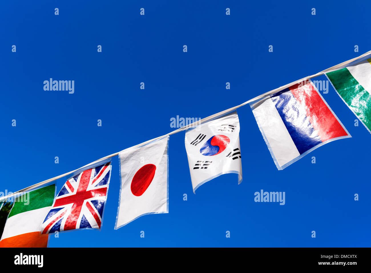 Multinational flags on a string at a garden party. Stock Photo