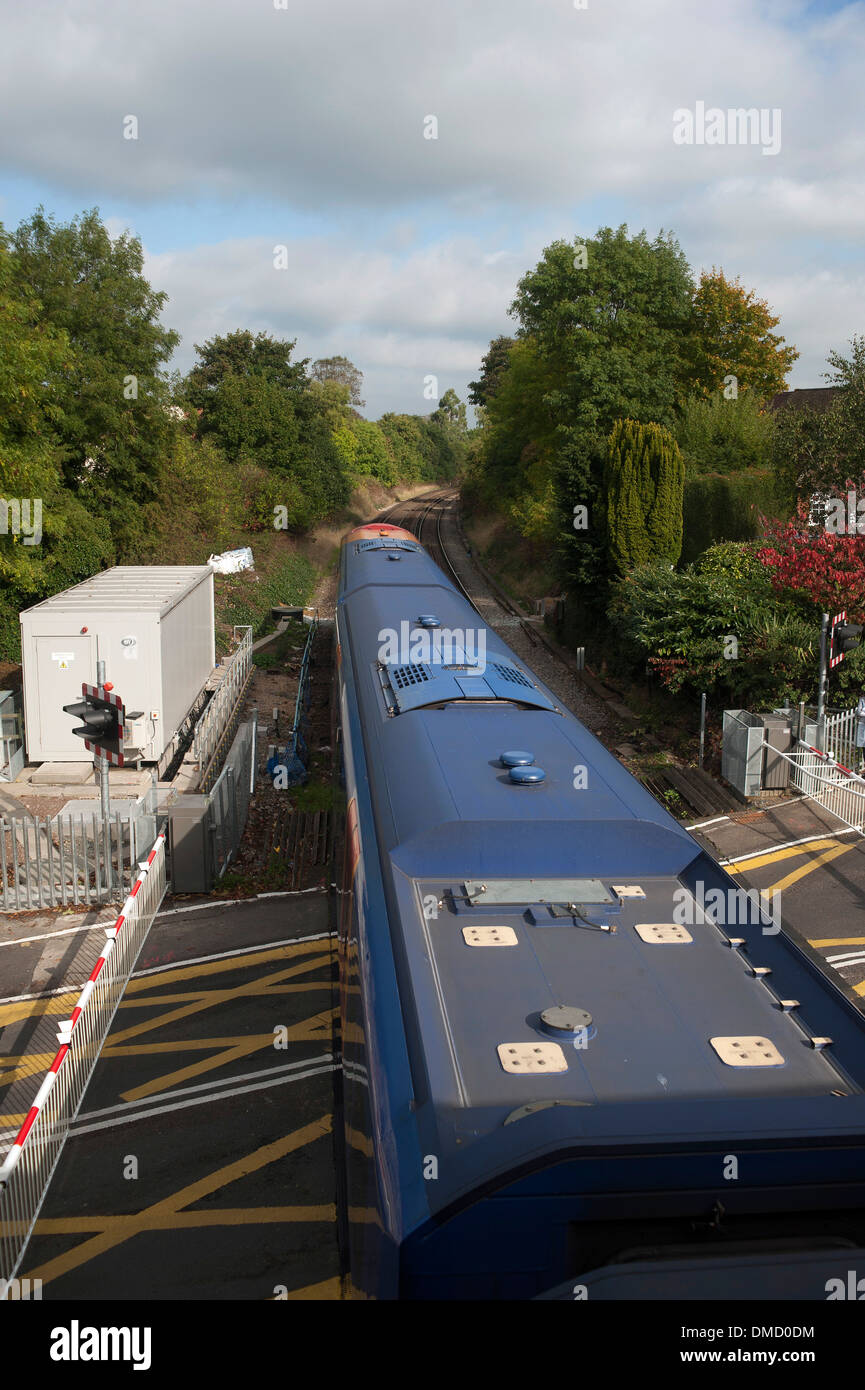 Train crosses the level crossing at Farnham train station, Surrey