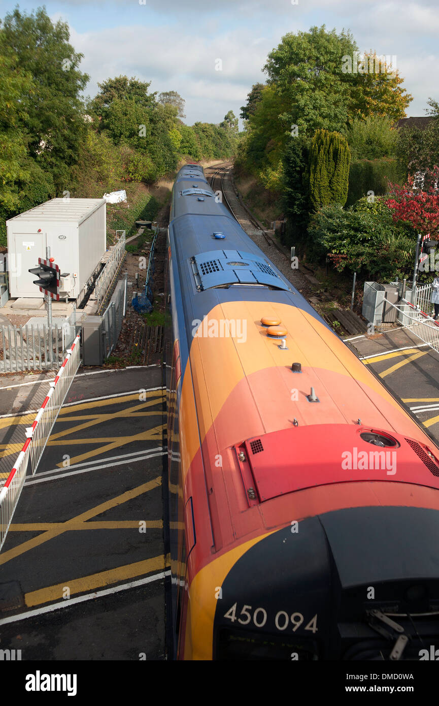 Train crosses the level crossing at Farnham train station, Surrey