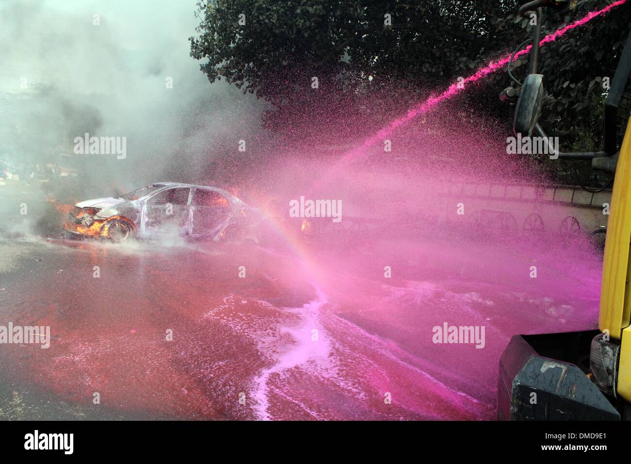 Dhaka, Bangladesh. 13th Dec, 2013. A police van sprays water to extinguish the fire set on by activists of Jamaat-e-Islami Party as they protested against the execution of their leader Abdul Quader Molla in Dhaka, Bangladesh, Dec. 13, 2013. Bangladesh has executed Abdul Quader Molla, an Islamist party leader convicted of war crimes in 1971, which is the first execution of a war criminal in the country. In protest against Molla's execution, his party Jamaat called countrywide dawn-to-dusk general strike for Sunday. Credit:  Shariful Islam/Xinhua/Alamy Live News Stock Photo