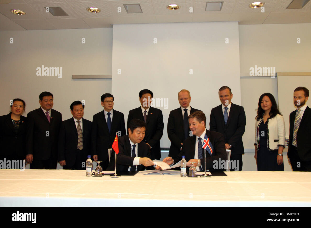 Reykjavik, Iceland. 13th Dec, 2013. A member of China's Shaanxi provincial delegation (L Front) and a representative of Iceland's Orka Energy Ltd. sign an agreement on expanding cooperation in developing geothermal resources, in Reykjavik, capital of Iceland, Dec. 13, 2013. Credit:  Xie Binbin/Xinhua/Alamy Live News Stock Photo