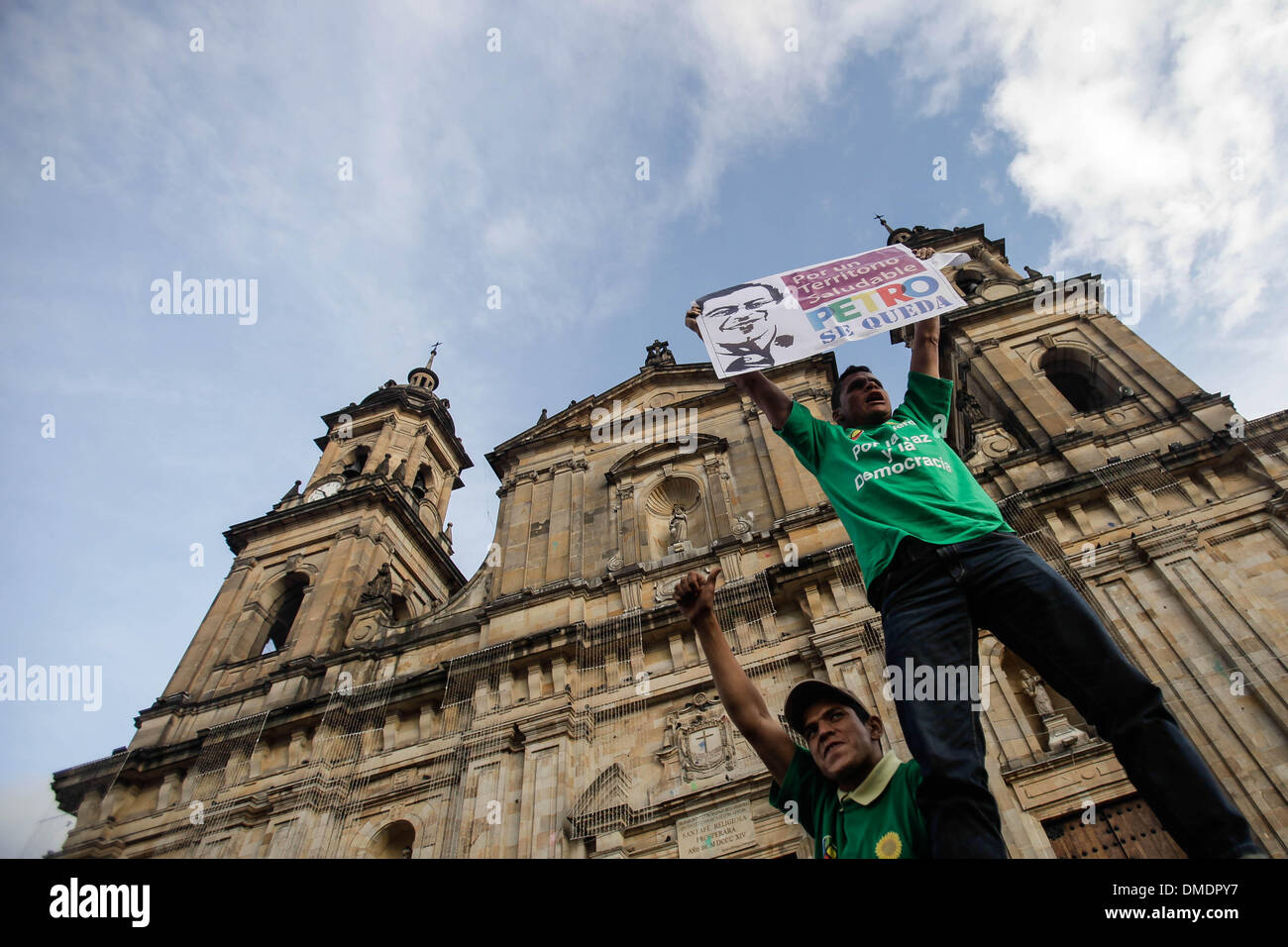 Bogota, Colombia. 13th Dec, 2013. A demonstrator holds a banner during the 'March for Peace and Democracy' during the fifth day of protests against the destitution of Bogota's Mayor Gustavo Petro at Bolivar's Square in the city of Bogota, capital of Colombia, on Dec. 13, 2013. Mayor of Colombian capital of Bogota was removed from post on Monday and barred from holding office for 15 years over mismanagement in the garbage collection scheme in the city last year. Credit:  Jhon Paz/Xinhua/Alamy Live News Stock Photo