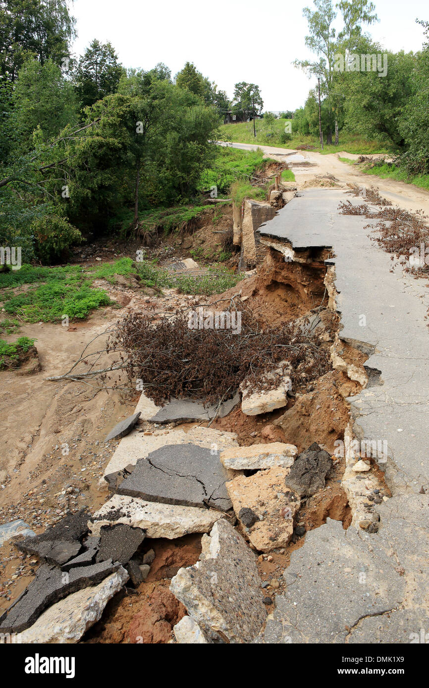 Collapse of the paved road in the forest. Stock Photo