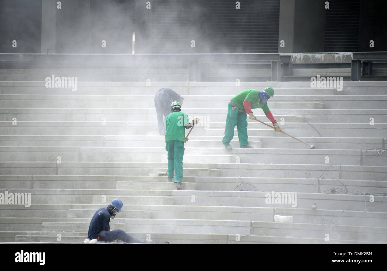 Construction workers stand on the terrace in the stadium 'Arena da Baixada' in Curitiba, Brazil, 14 December 2013. The Arena de Baixada is one of the stadiums for the FIFA World Cup 2014 in Brazil. Photo: MARCUS BRANDT Stock Photo