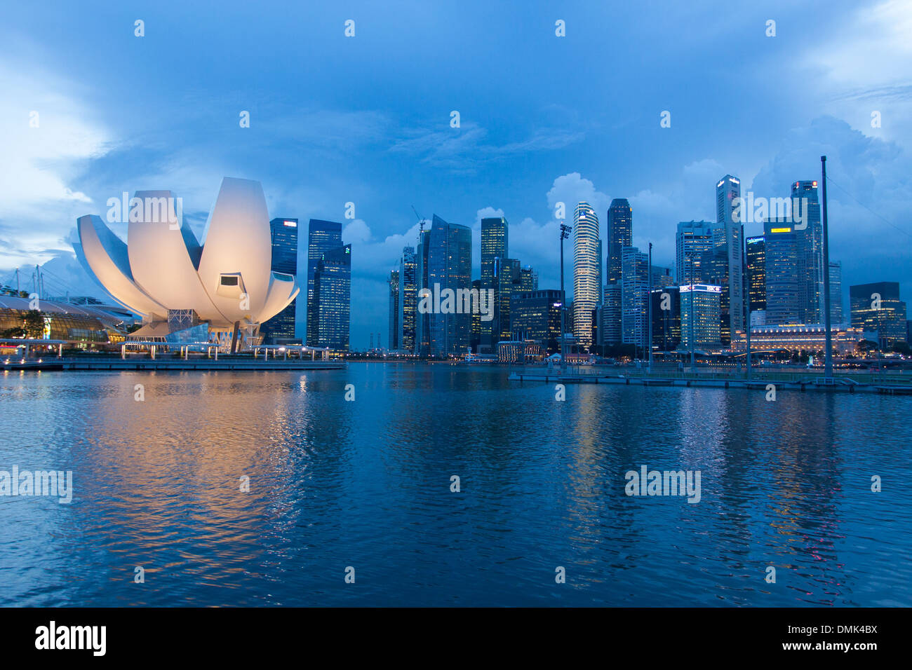 EVENING FALLING AFTER A STORM OVER MARINA BAY, THE LOTUS FLOWER-SHAPED DOME OF THE ART SCIENCE MUSEUM AND THE BUILDINGS IN THE CENTRAL BUSINESS DISTRICT, SINGAPORE Stock Photo