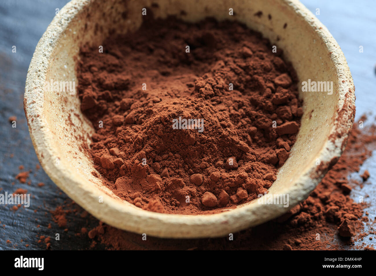 Cocoa powder in a bowl on black background, close-up Stock Photo