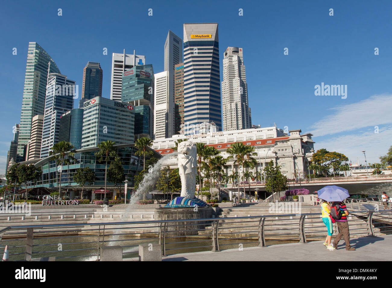 TOURISTS LOOKING AT THE SCULPTURE MERLION, SYMBOLISING SINGAPORE, AT THE FOOT OF THE OFFICE BUILDINGS IN THE FINANCIAL DISTRICT, CENTRAL BUSINESS DISTRICT, SINGAPORE Stock Photo