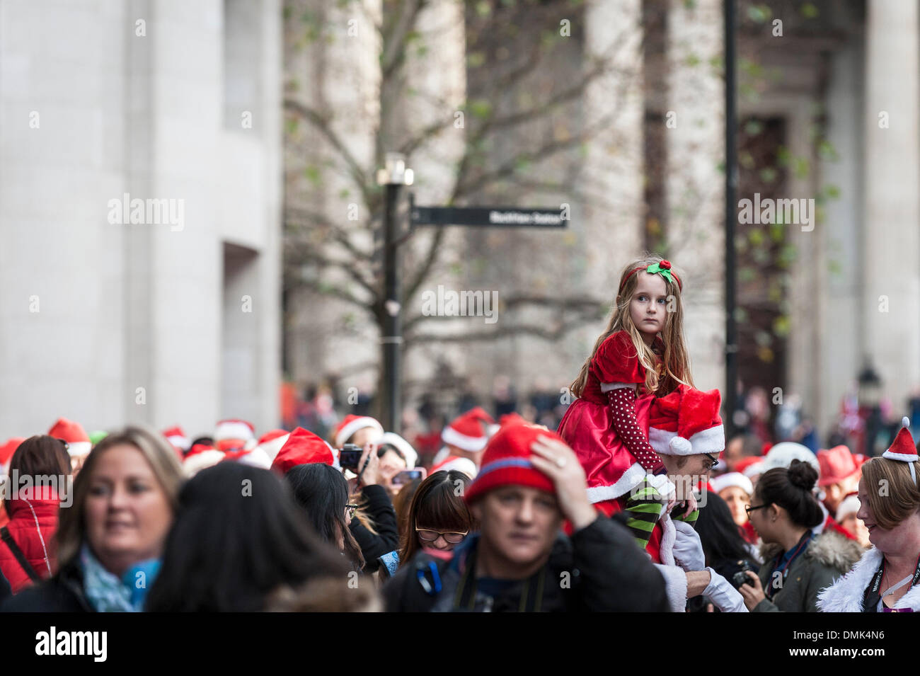 London, UK. 14th December, 2013. A young girl being carried on her ...