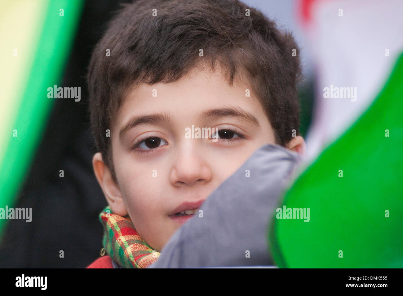 London, UK. 14th December 2013. A small boy peers out from between flags as Kurds demand that the Kurdish issue in Syria is added to the agenda of the January 2014 Geneva II peace conference. Credit:  Paul Davey/Alamy Live News Stock Photo