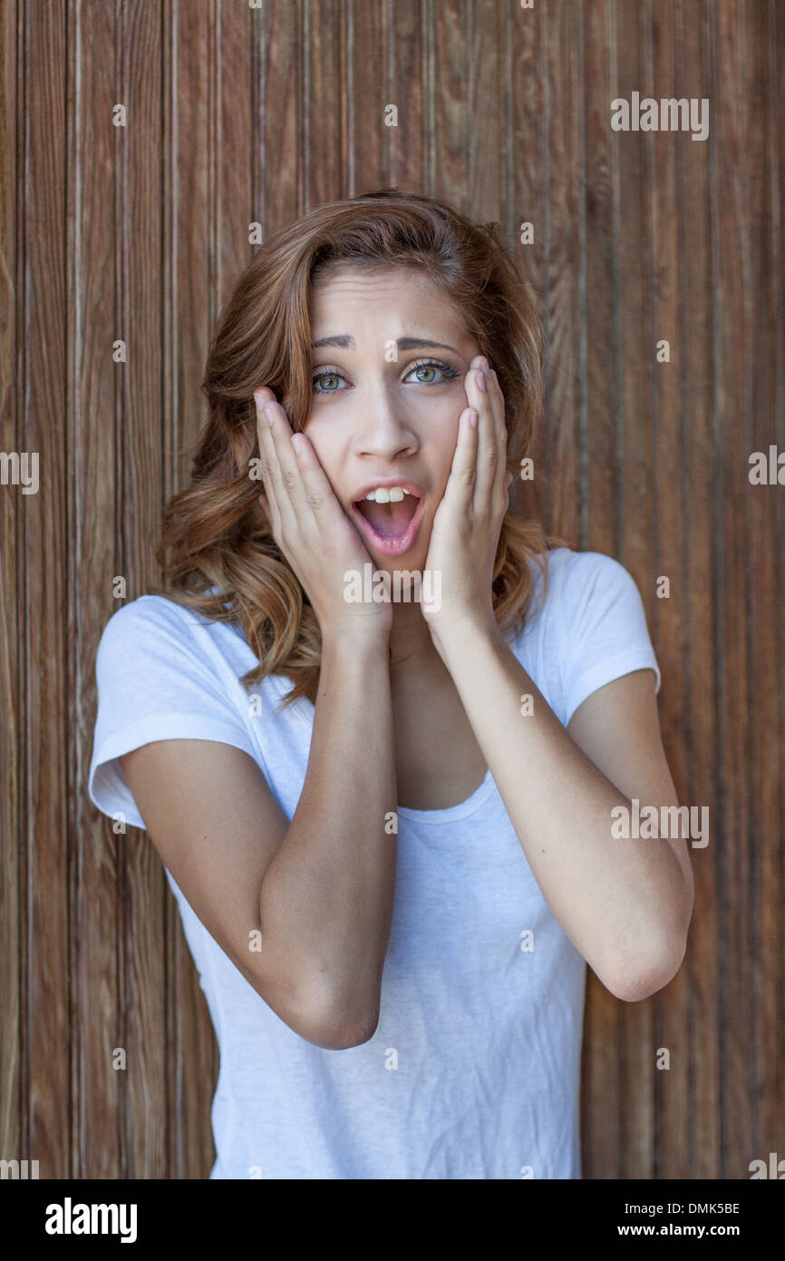 Oh, My Gosh! - vertical orientation close up of a lovely teenage girl with hands on her face and look of disbelief Stock Photo