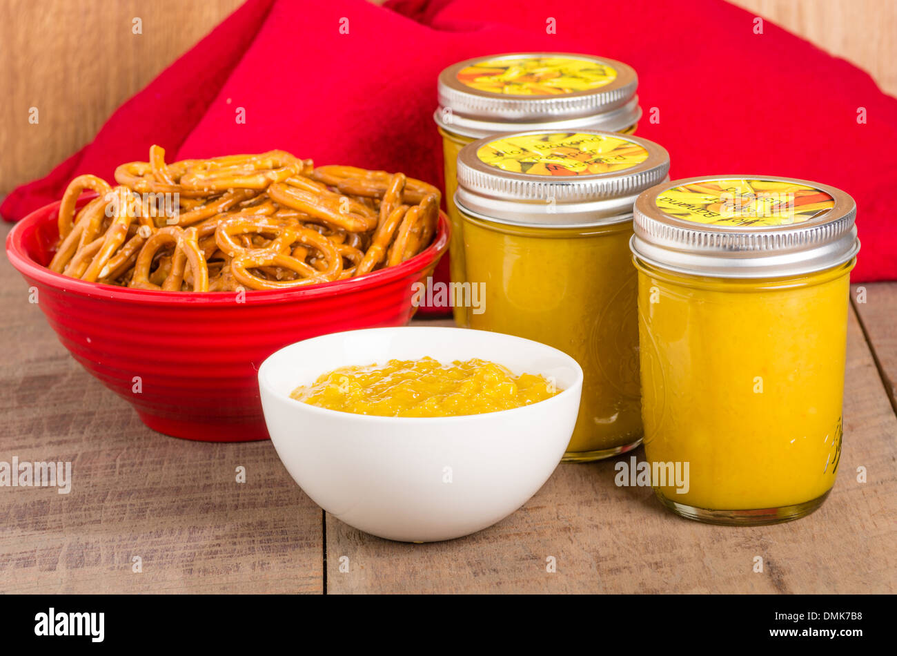 Jars of fresh homemade yellow mustard with pretzels Stock Photo