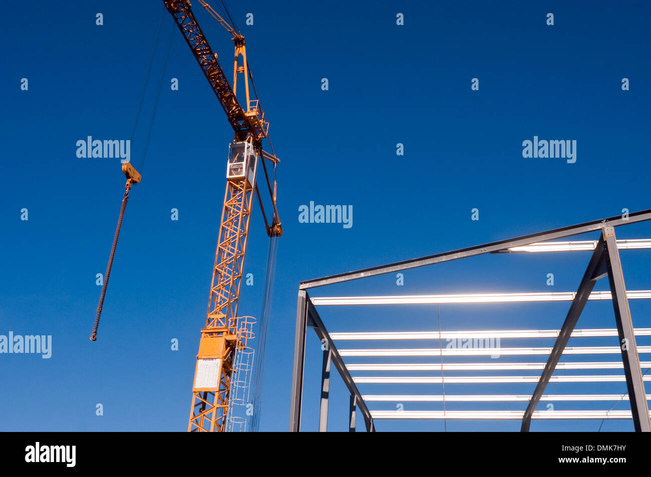 Tower crane and new warehouse roofing steelwork / factory building site - France. Stock Photo