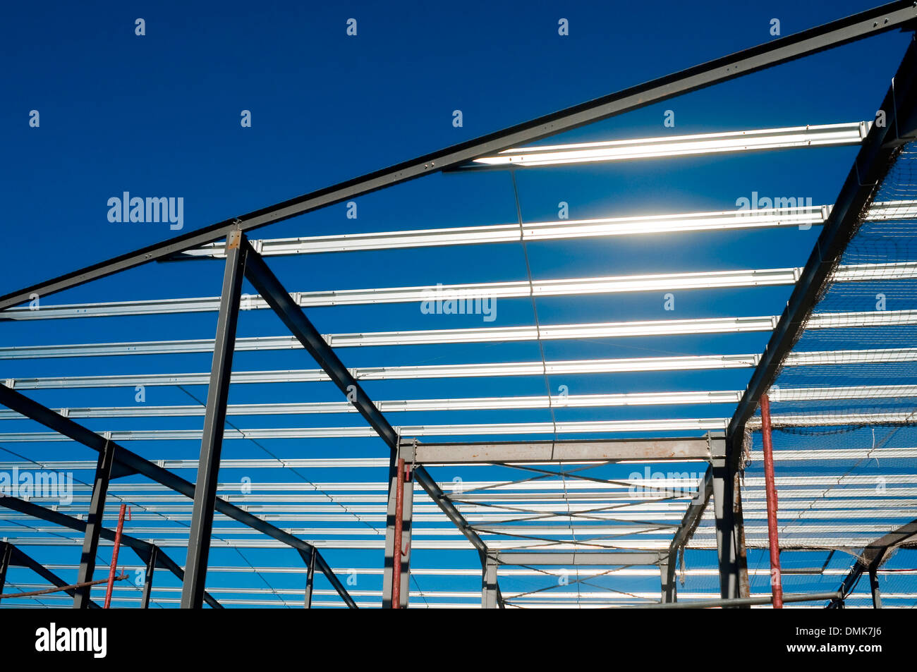 Tower crane and new warehouse roofing steelwork / factory building site - France. Stock Photo