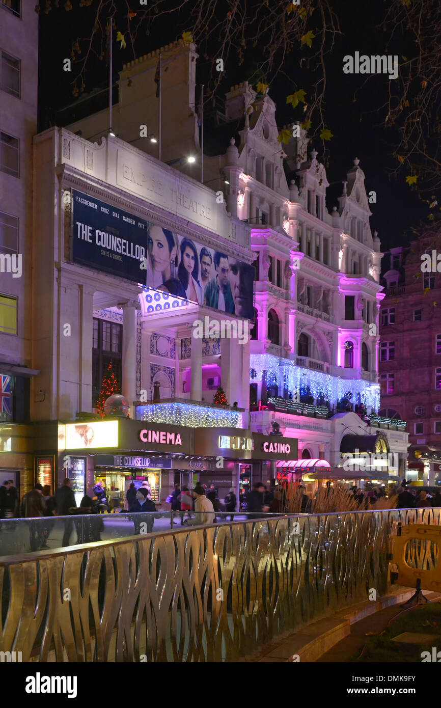 People outside Empire Cinemas and Casino premises floodlighting & illuminated signs at night in winter at Leicester Square London West End England UK Stock Photo