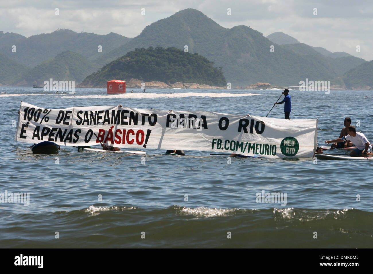 Copacabana Beach, Rio de Janeiro, Brazil, 14th Dec 2013. Activists of the "Verao do Saneamento" (Summer of Sanitation) campaign open a banner in the sea during the "King and Queen of the Sea" open water swimming tournament. They ask for a governmental sanitation plan that encompasses all the city. Credit:  Maria Adelaide Silva/Alamy Live News Stock Photo