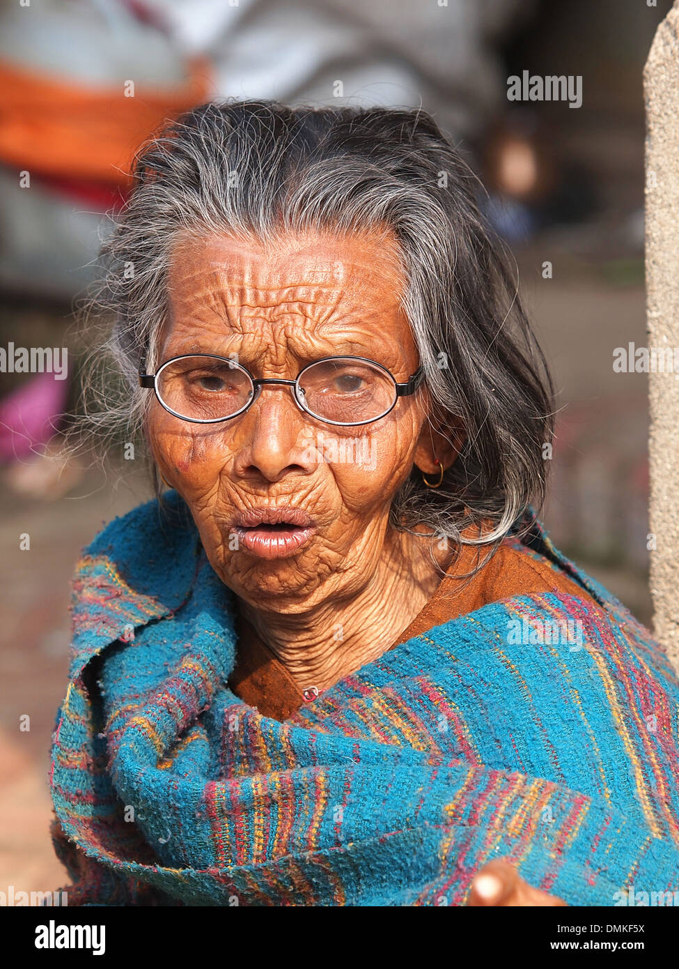 very old woman on the street in blue dress Stock Photo Alamy