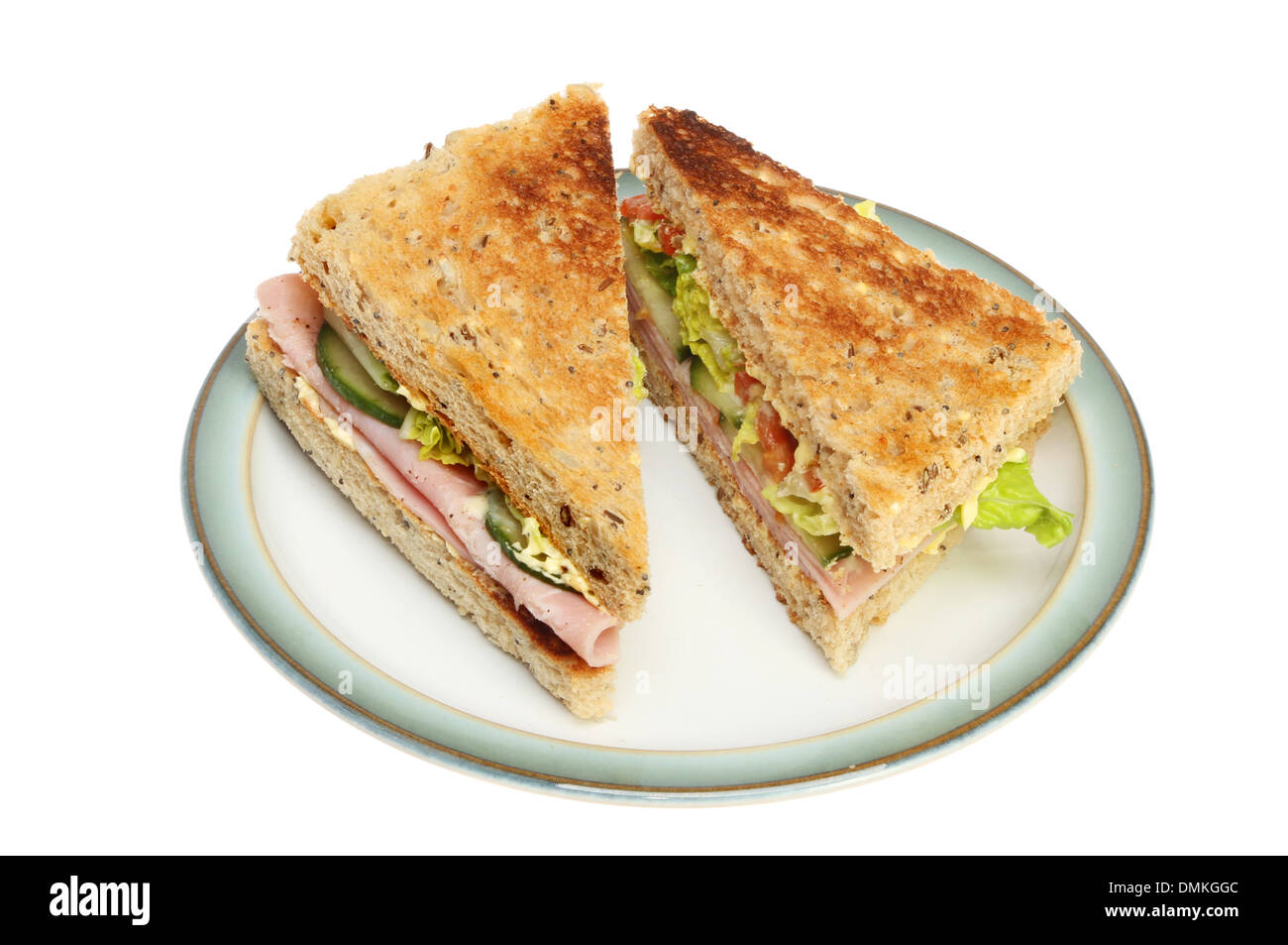 Ham salad sandwich on toasted seeded bread on a plate isolated against white Stock Photo