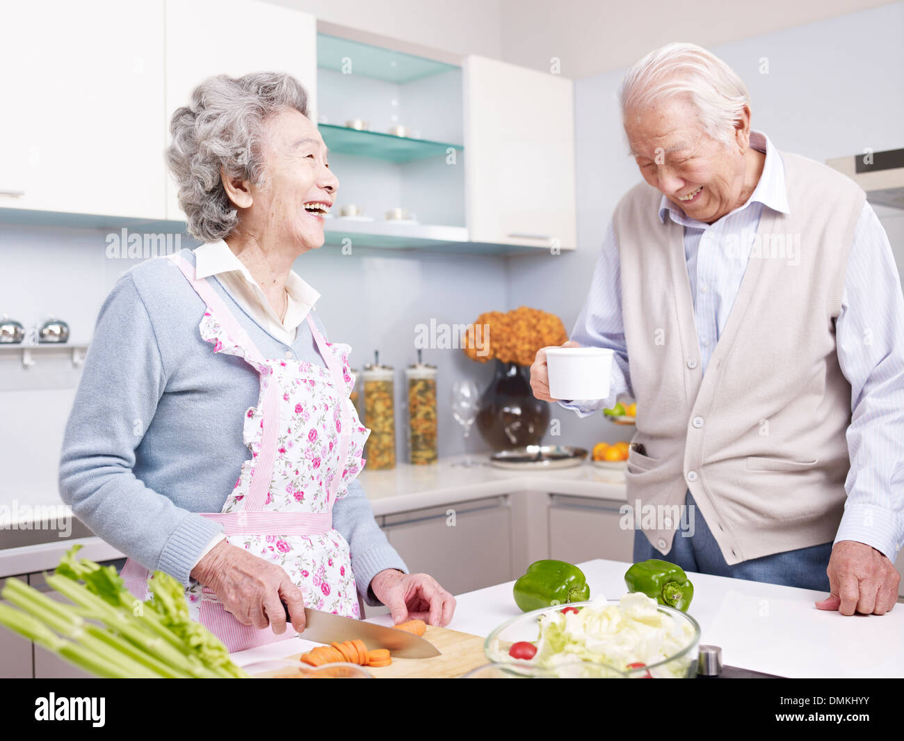 senior couple talking and laughing in kitchen Stock Photo