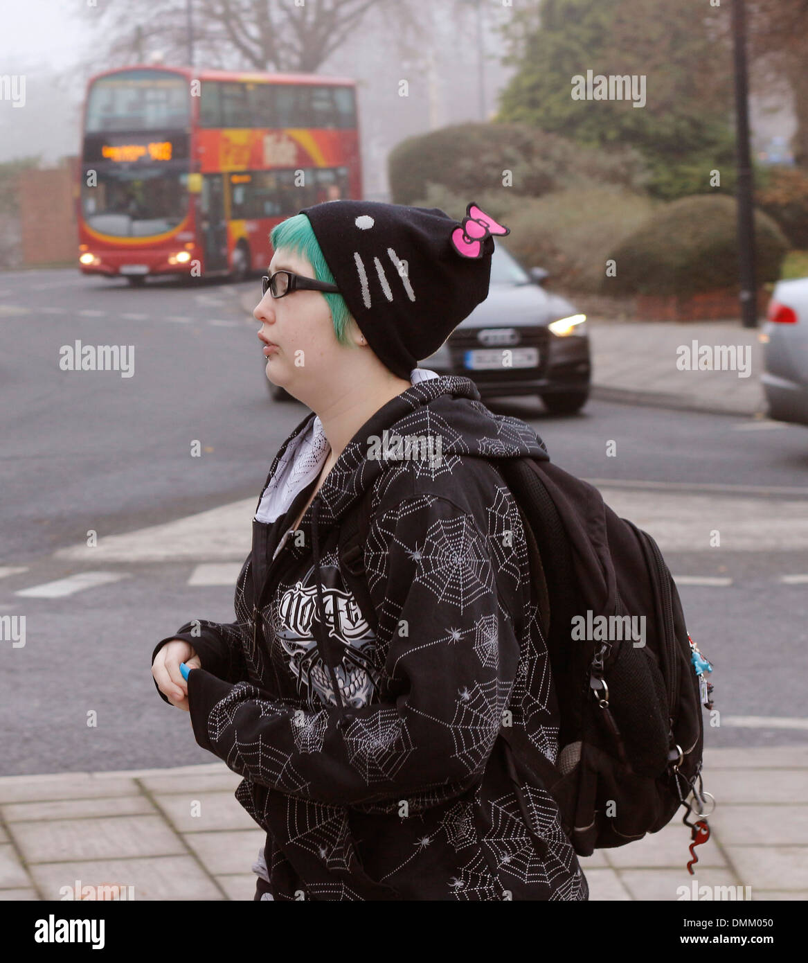 Young urban girl with green hair and a cat hat walking in Bristol, December 2013 Stock Photo