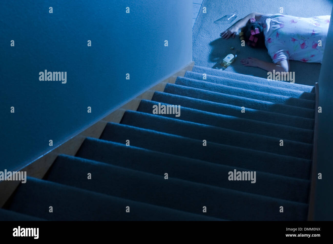 Woman lying at the bottom of stairs mystery with spilled alcohol bottle