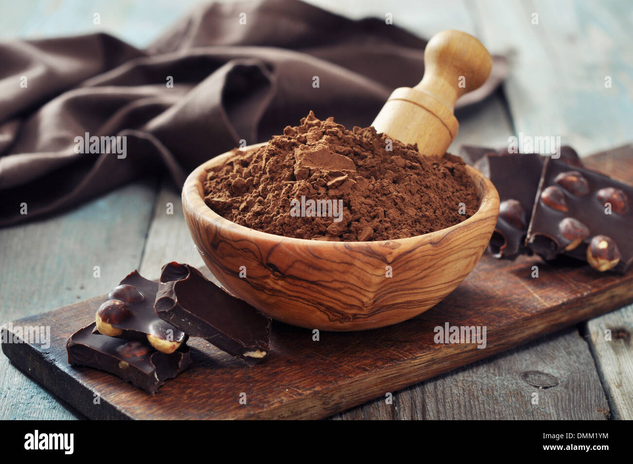 Carob powder in bowl with chocolate pieces on wooden background Stock Photo