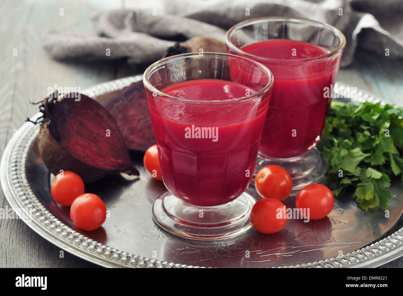 Beetroot smoothie in glass with fresh vegetables on round tray Stock Photo