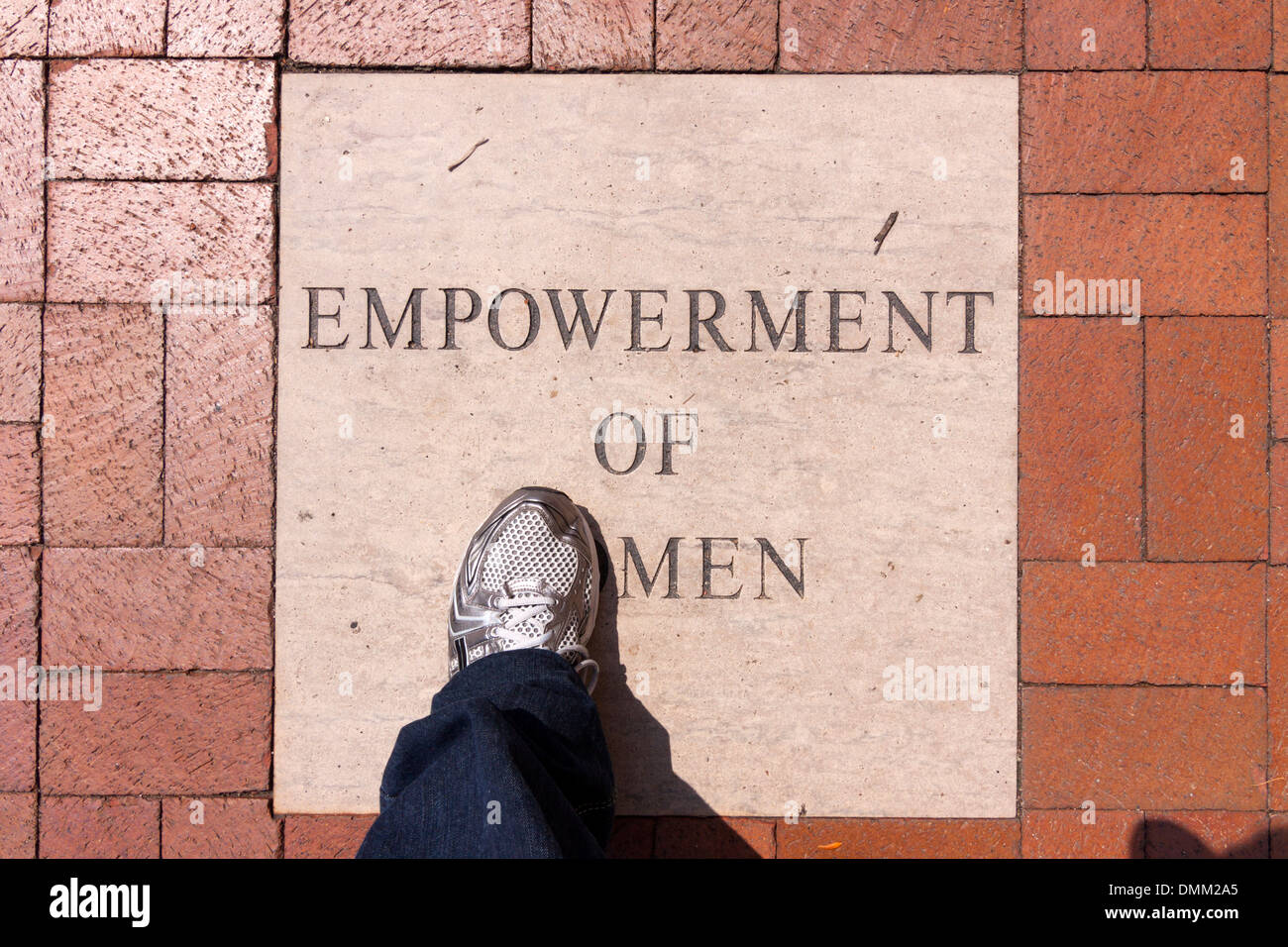 A foot steps on an Empowerment of Women sidewalk stone in Columbus, Ohio. Stock Photo