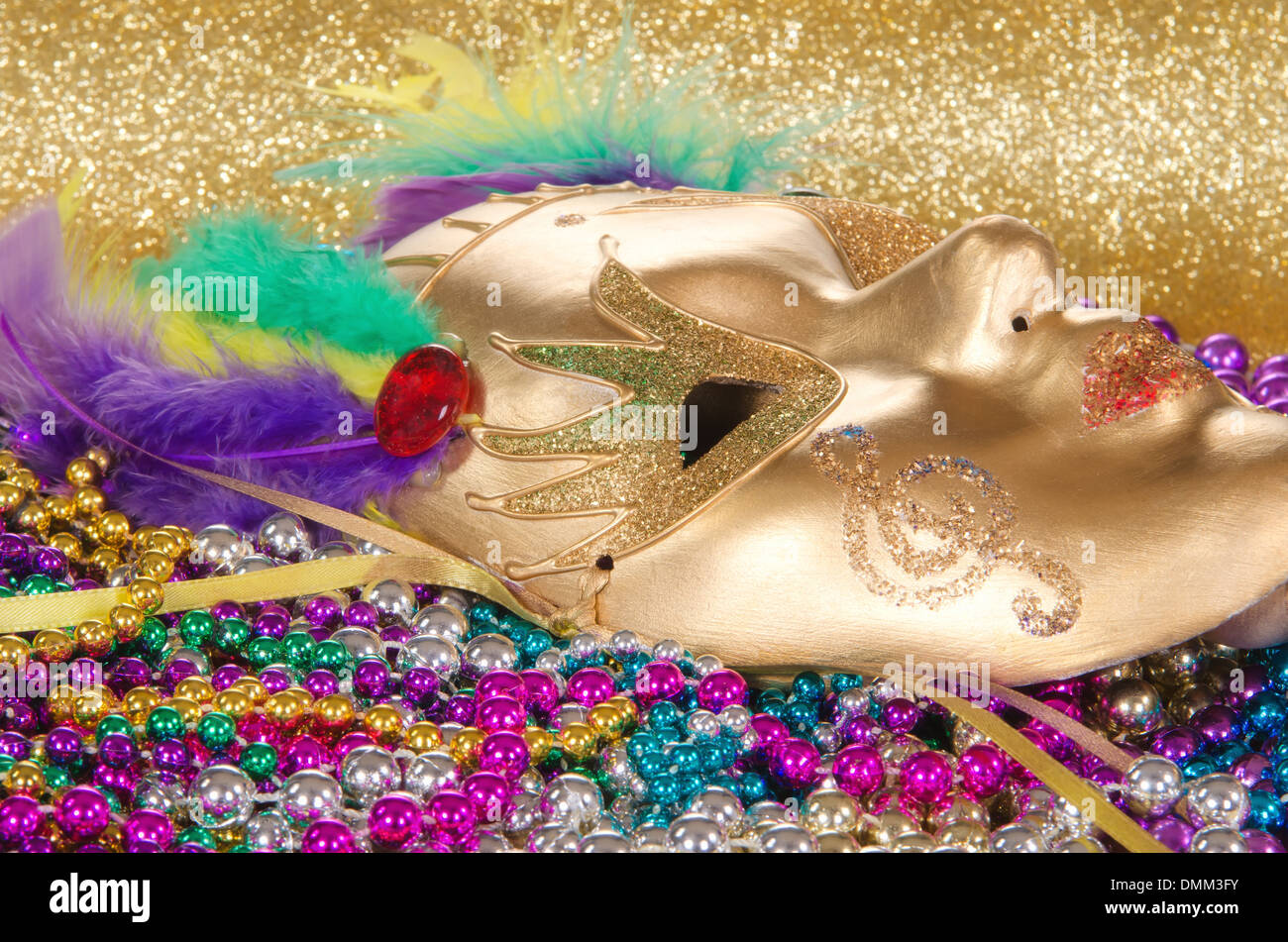 Festive Mardi Gras beads and a golden mask Stock Photo