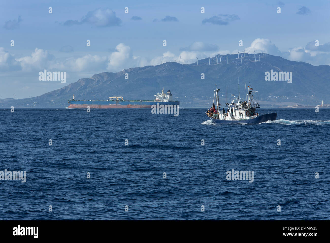 Spain, Andalusia, Tarifa, Oil tanker and Spanish fishing boat on the ocean Stock Photo