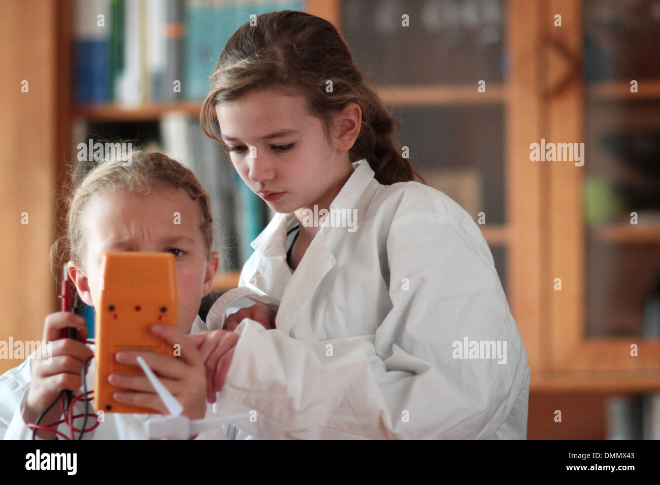 girls working with a electrical device with lab coat Stock Photo