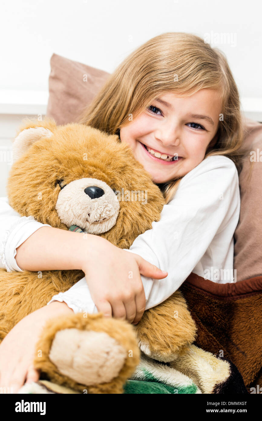 girl cuddling teddy bear