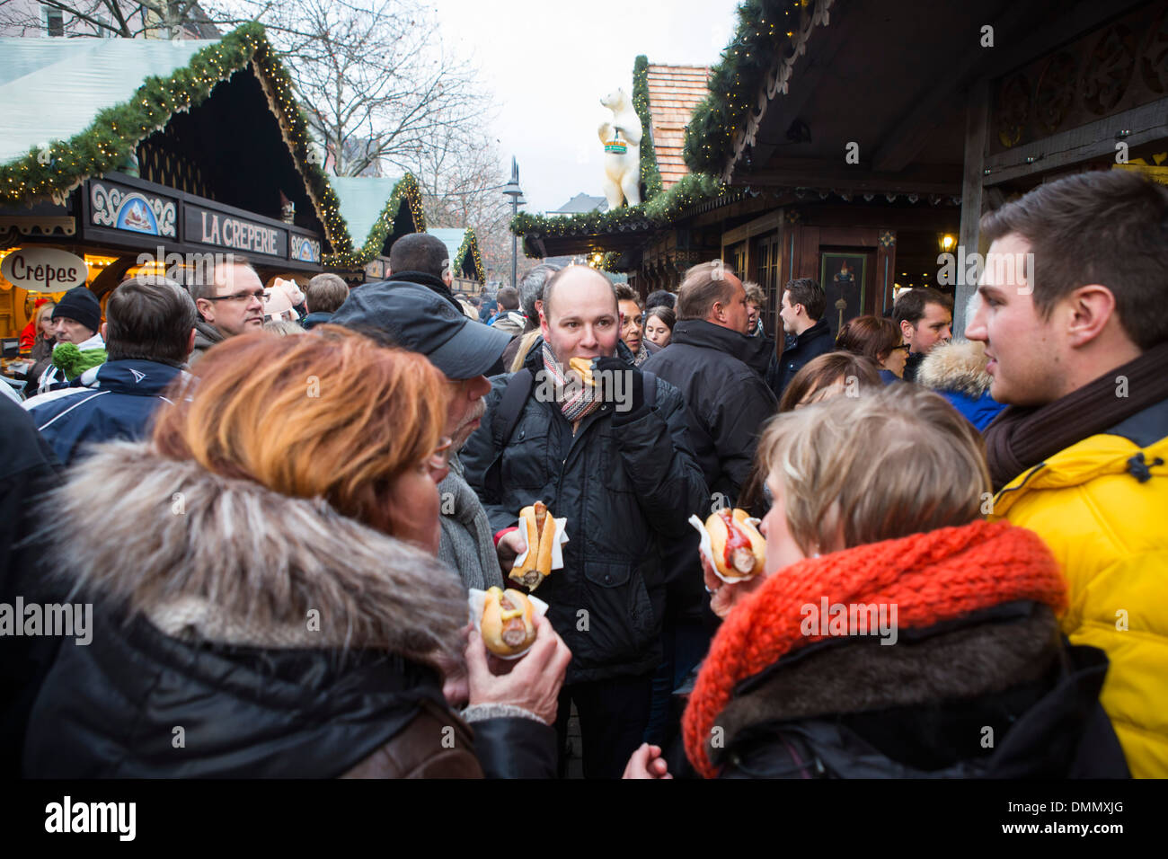 Christmas Market of Cologne: People eating roll sausage at the  Altstadt or older part of the city Stock Photo