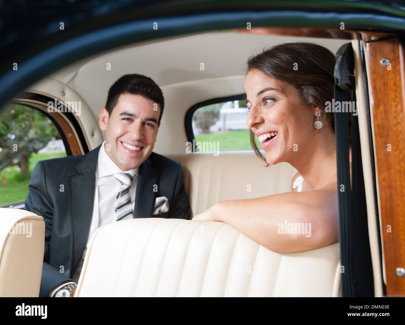 Bride and groom inside a classic car. They are happy Stock Photo - Alamy
