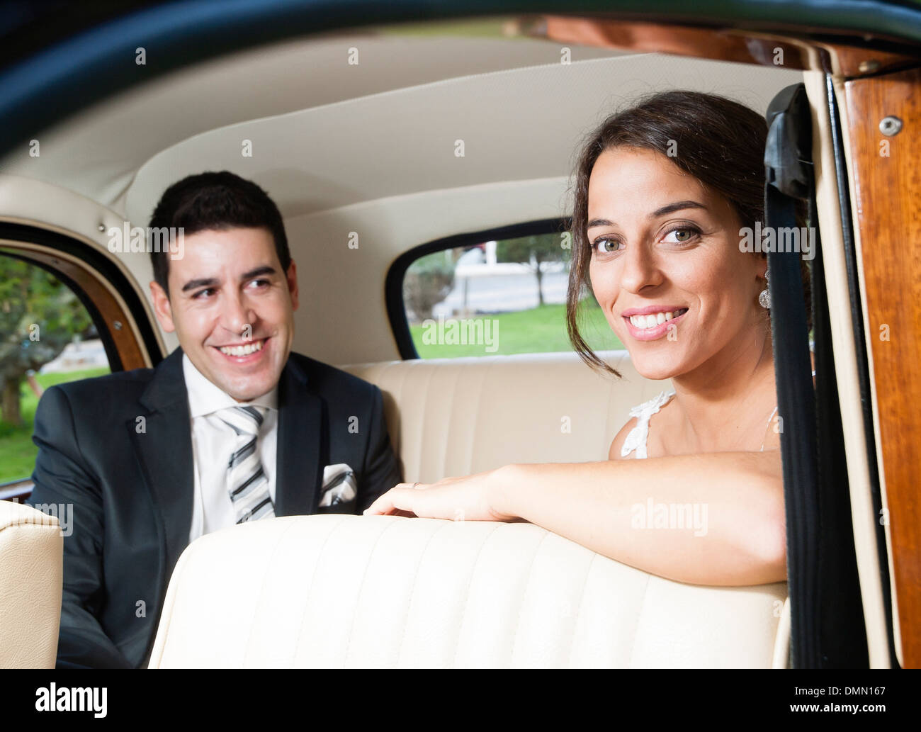 Bride and groom inside a classic car. They are happy Stock Photo - Alamy