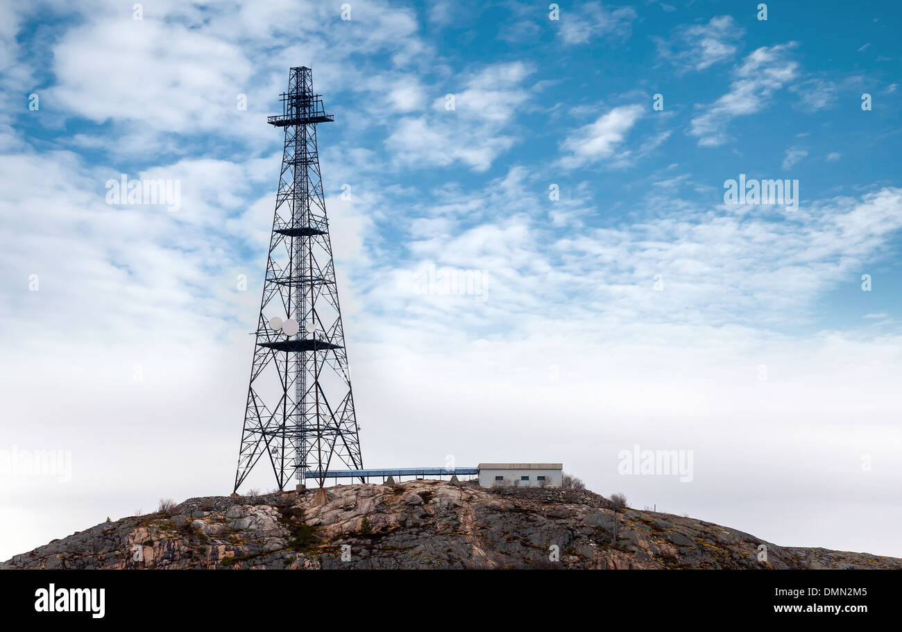 Big communication radio tower above blue cloudy sky Stock Photo