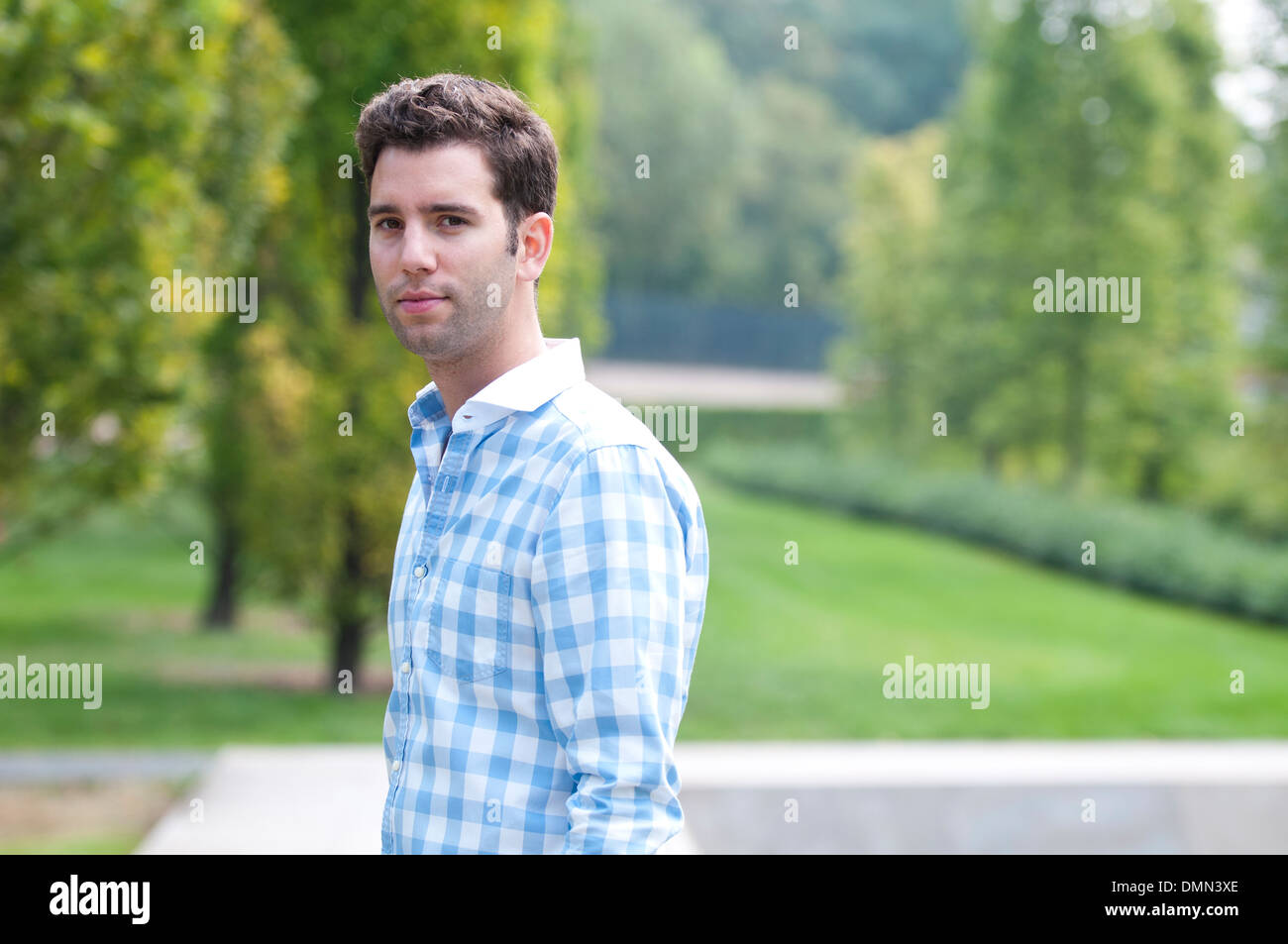 Young man is standing in a park Stock Photo