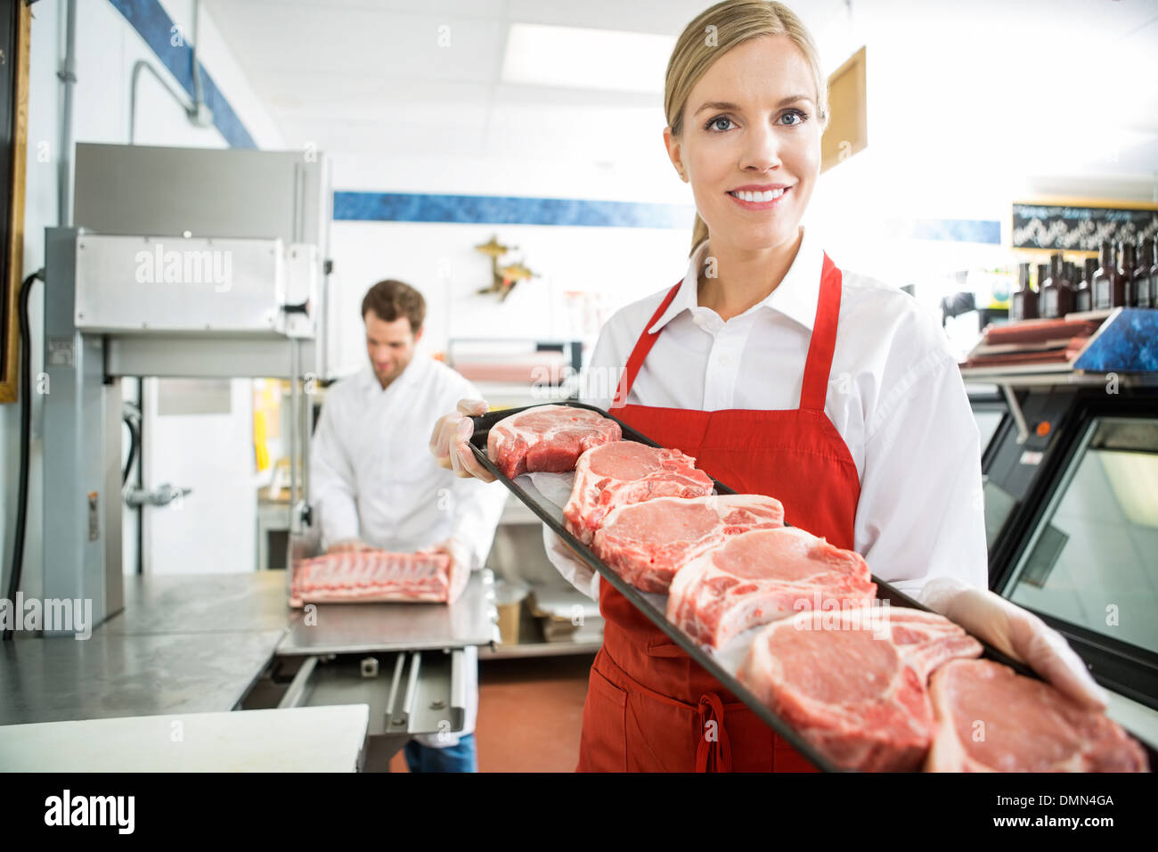 Happy Butcher Showing Meat Tray In Store Stock Photo