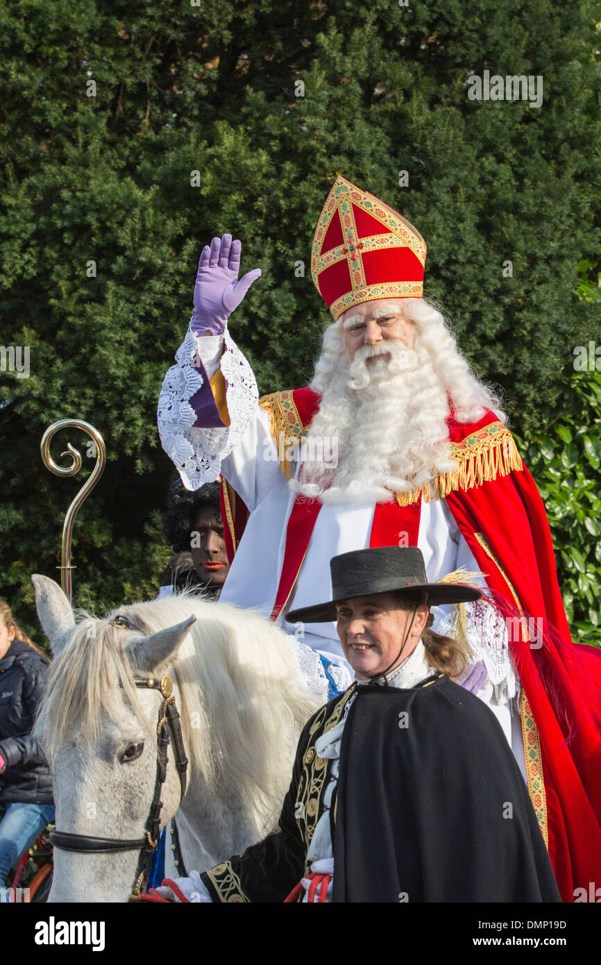 Netherlands, Kortenhoef, Saint Nicholas eve. Saint on white horse or roan and Black Petes make a