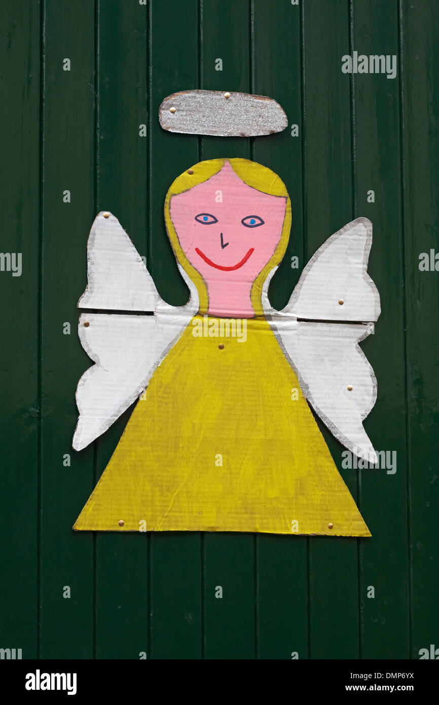 angel decoration with halo on green wooden door Stock Photo