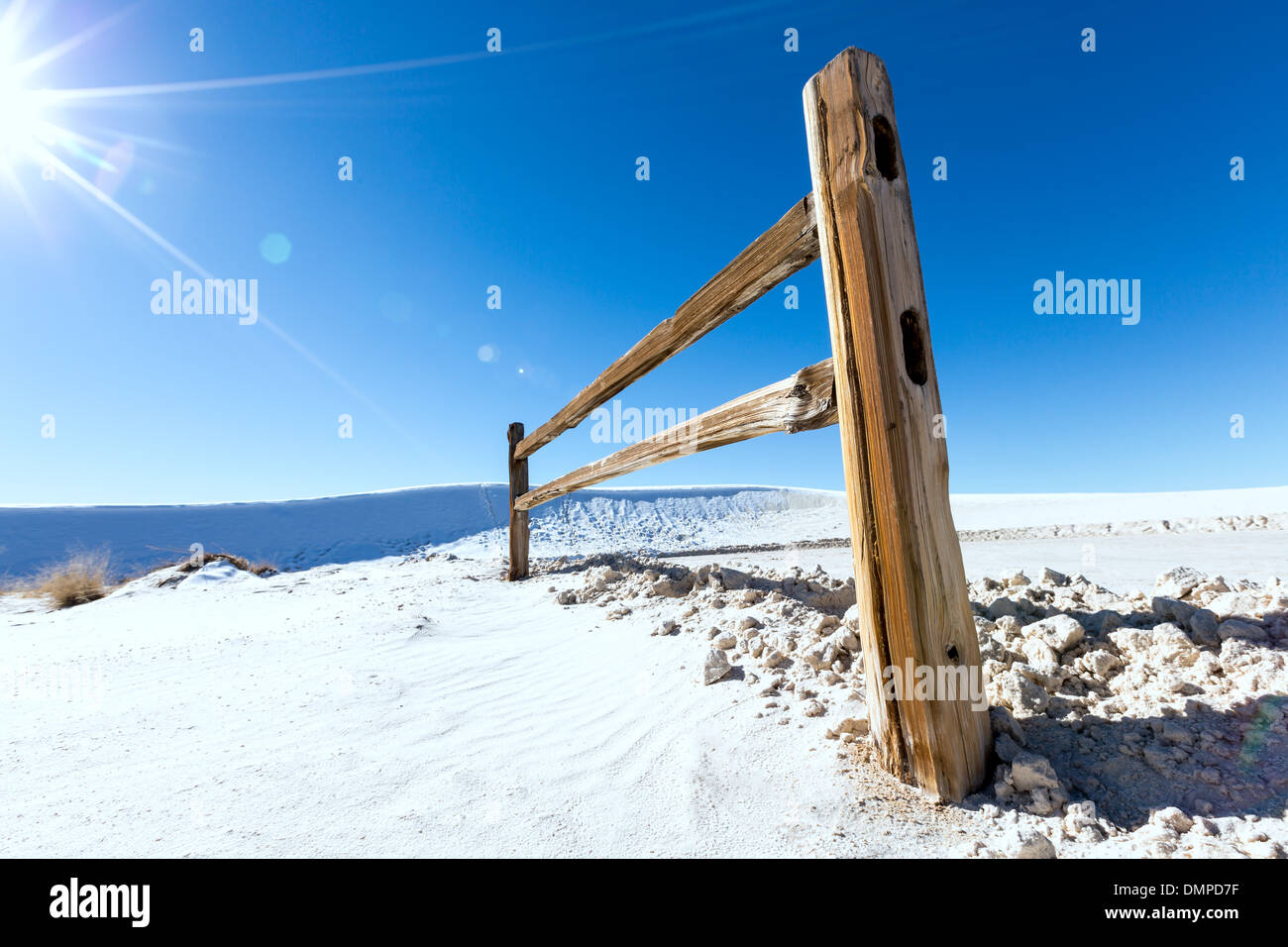 wooden fence in snowy wilderness and sun Stock Photo
