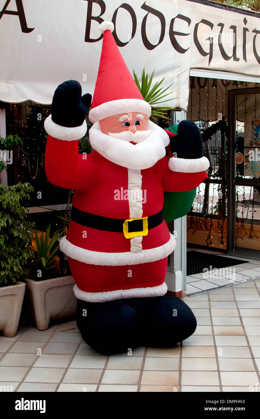 Inflatable Father Christmas in shopping street, Caleta de Fuste, Fuerteventura, Canary Islands. Stock Photo