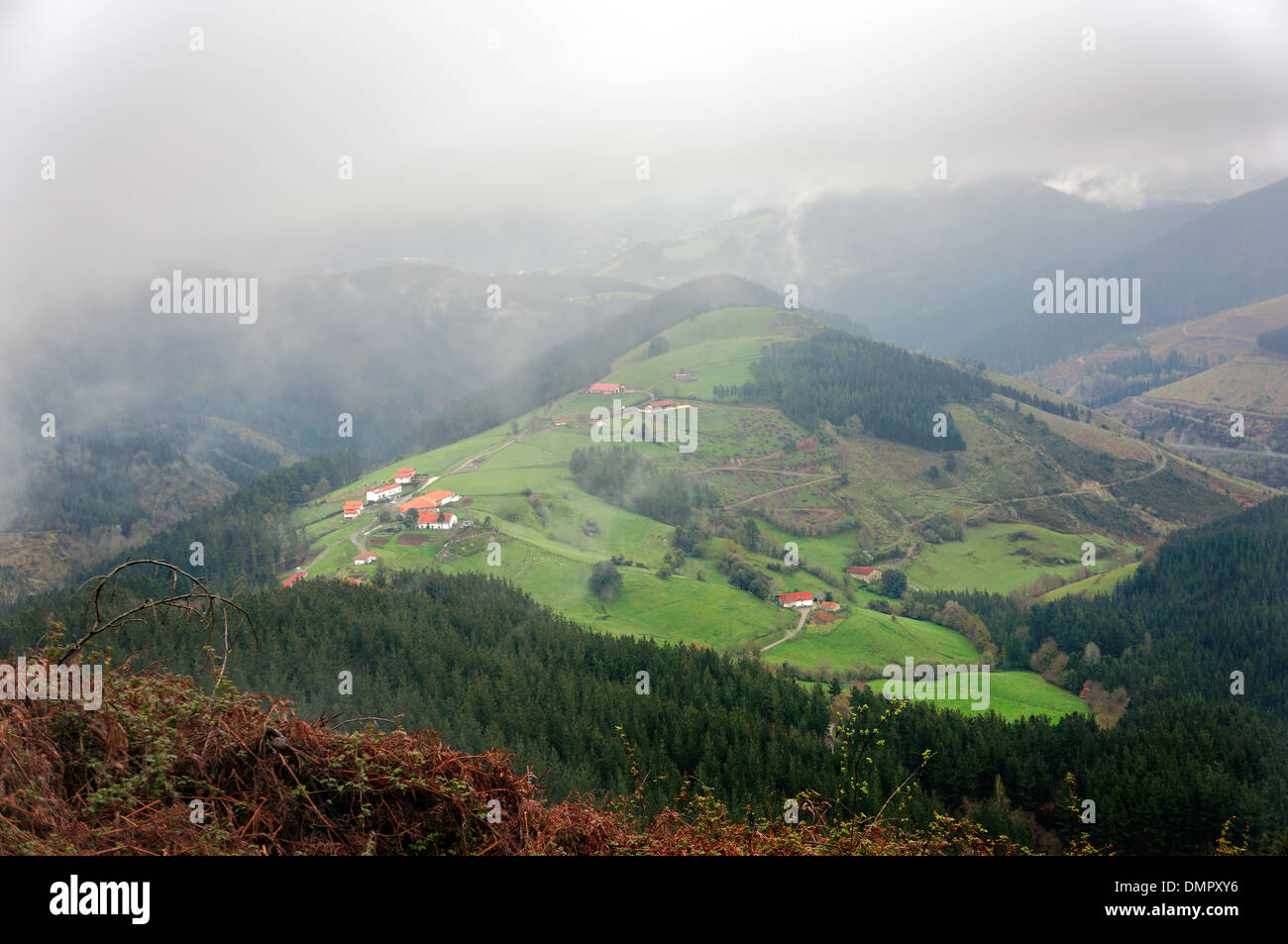 countryside village with some typical basque country houses on misty mountain Stock Photo
