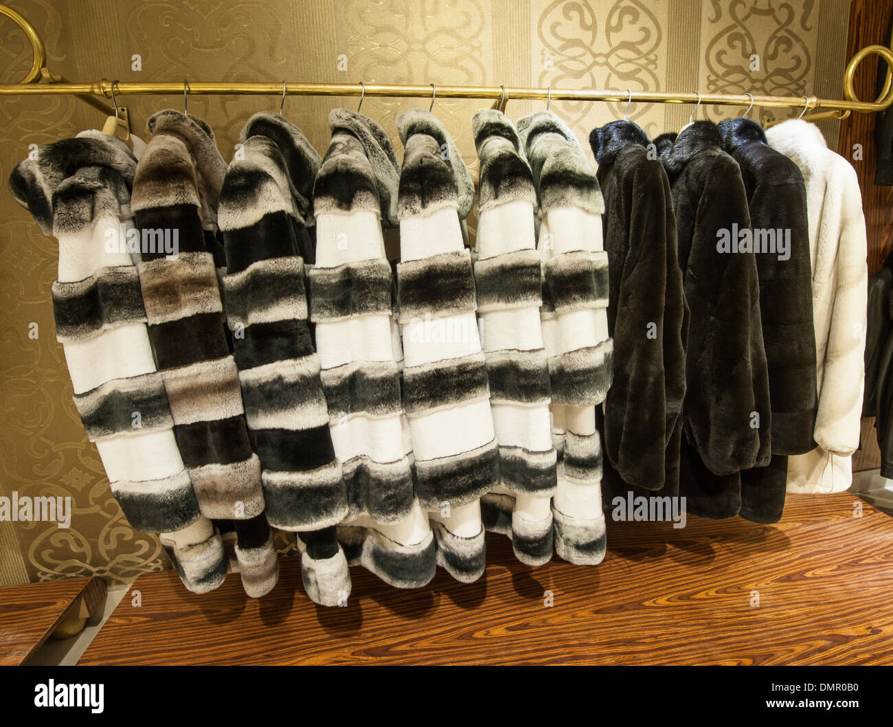 Expensive genuine fur coats hanging on a rail in shop Stock Photo