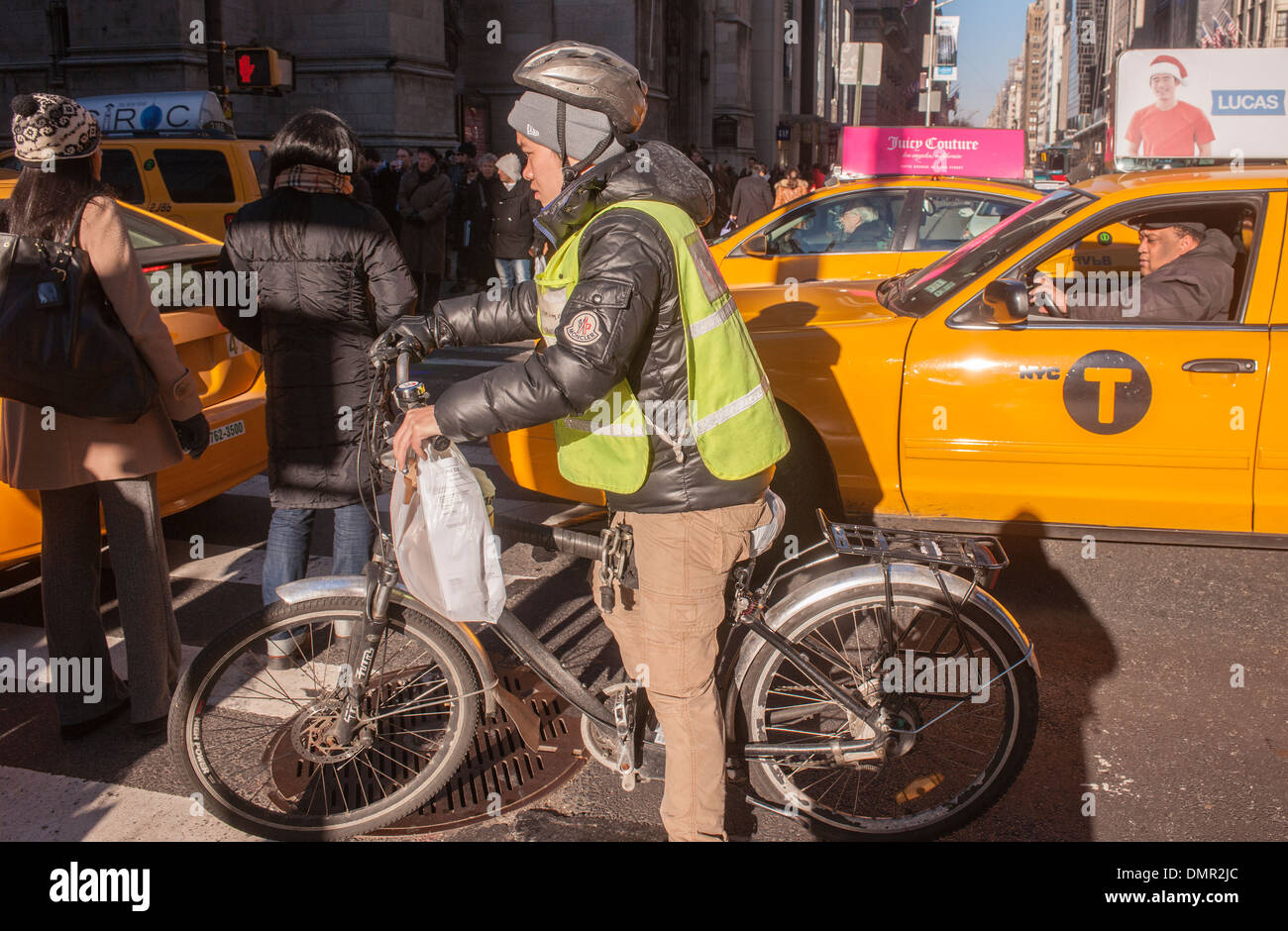 Food delivery bicyclist on Fifth Avenue in New York maneuvers through gridlock Stock Photo