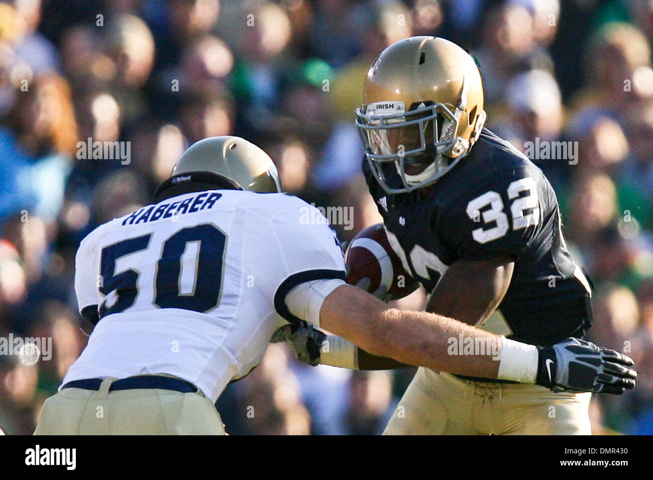 Notre Dame wide receiver Theo Riddick (32) takes a hit from Navy linebacker Tony Haberer (50) during game action.  Navy at Notre Dame at Notre Dame Stadium in South Bend, Indiana.  Navy defeated Notre Dame 23-21. (Credit Image: © Scott Grau/Southcreek Global/ZUMApress.com) Stock Photo
