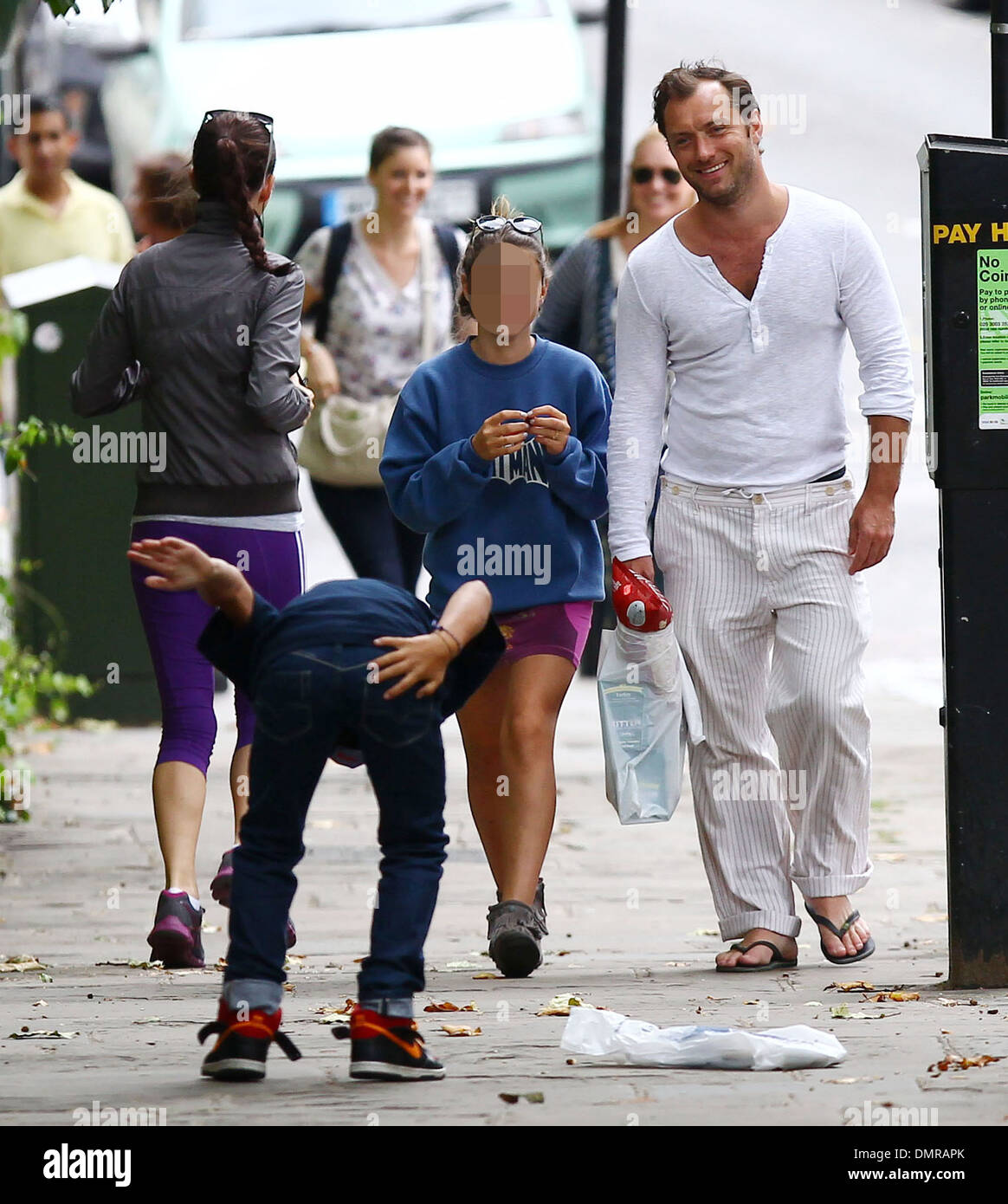 Jude Law with his daughter Iris and son Rudy walking through Primrose Hill in London Rudy jokingly slaps his behind at Stock Photo