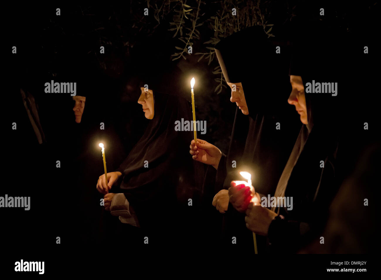 Orthodox nuns with prayer candles attending a night liturgy at