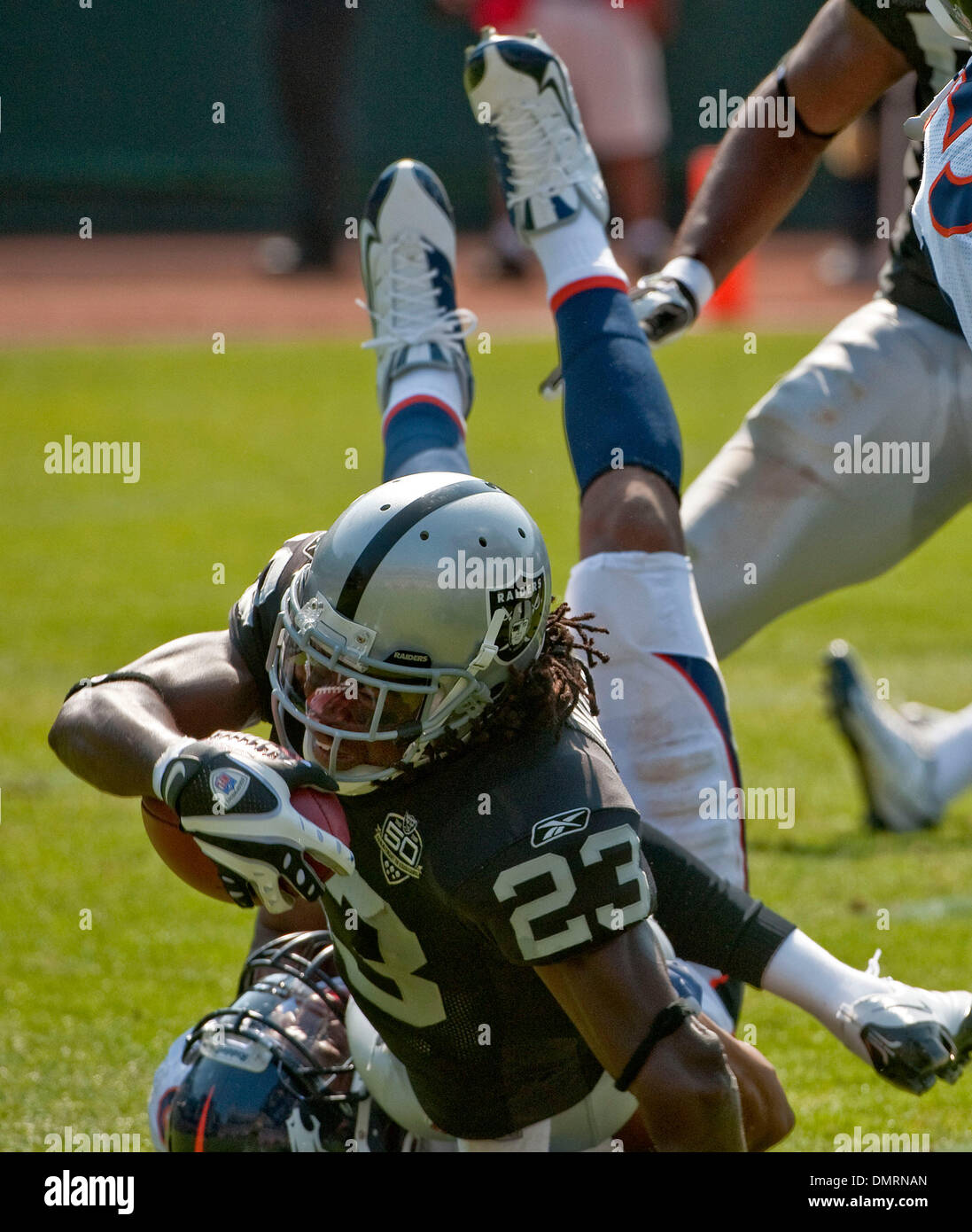 Sep 27, 2009 - Oakland, California, U.S. - Oakland Raiders vs Denver Broncos  at Oakland-Alameda County Coliseum Sunday, September 27, 2009, Oakland Raiders running back Gary Russell #23 is tripped up by Denver player on runback. (Credit Image: © Al Golub/ZUMApress.com) Stock Photo