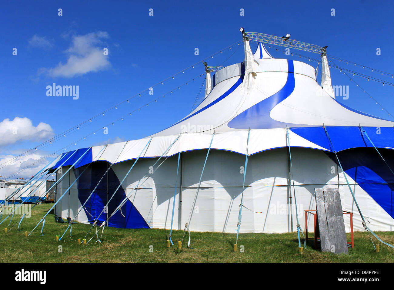 Blue and white striped circus tent in field. Stock Photo