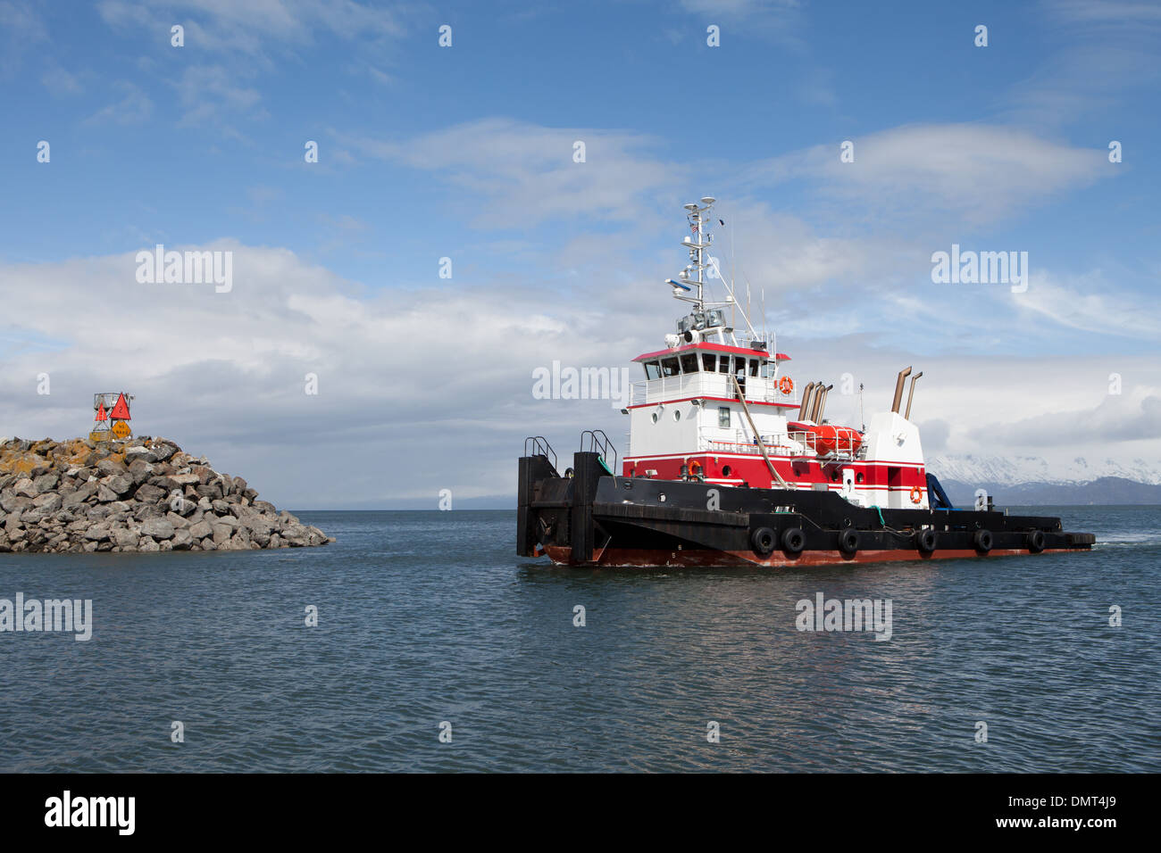 White and red tug boat entering the harbor in Homer, Alaska. Stock Photo